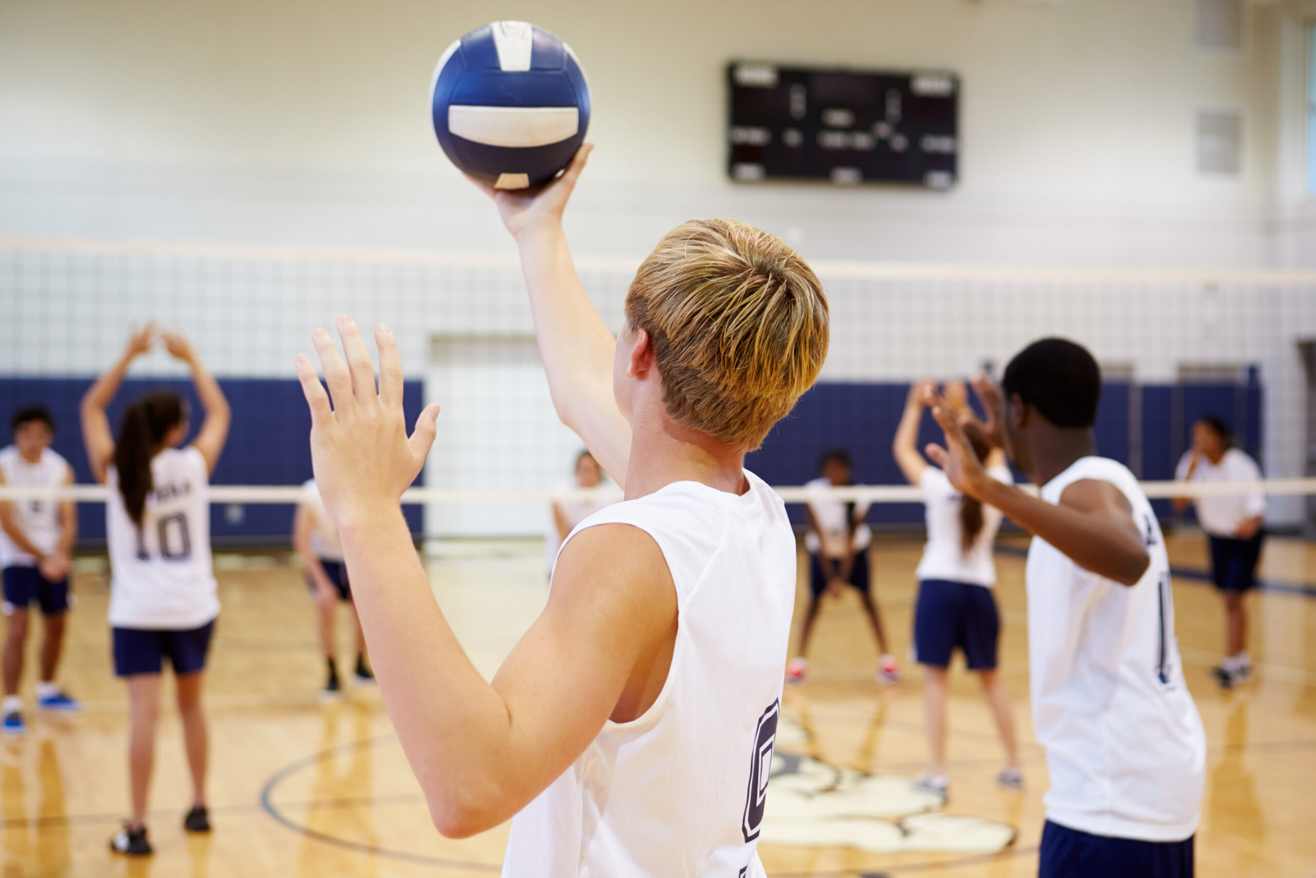 Ein Junge der einen Aufschlag im Volleyball macht